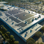 Electric photovoltaic solar panels installed on shopping mall building rooftop for production of green ecological electricity. Concept of producing sustainable energy.